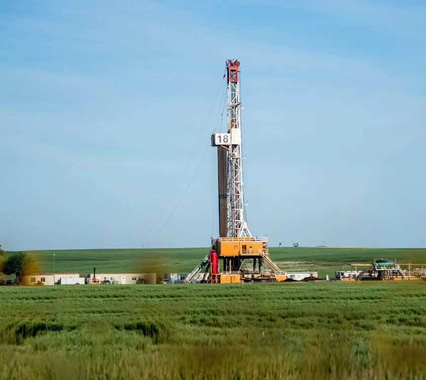 A drilling rig in the middle of an open field.