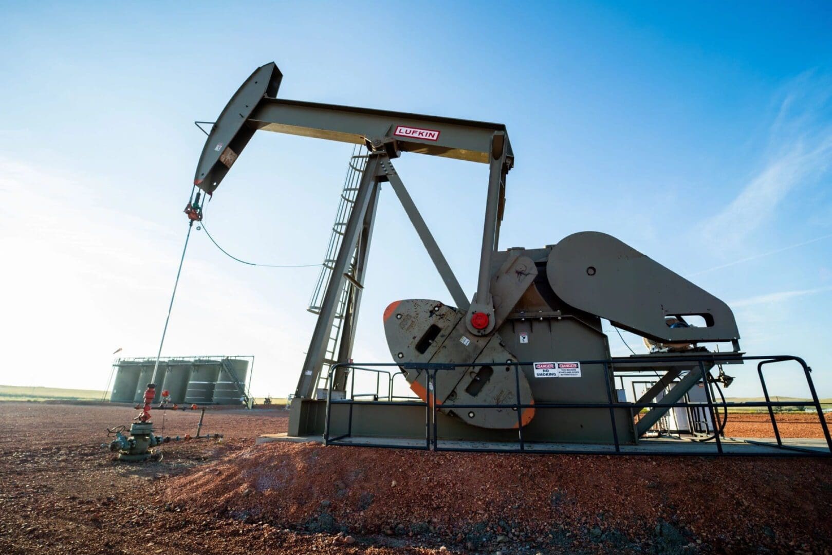 A pump jack is shown in the middle of an open field.