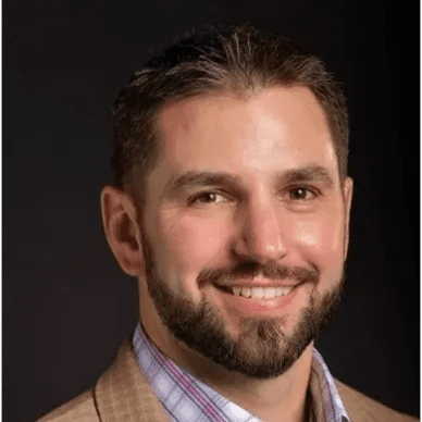 A man with a beard and suit jacket